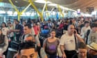 Queues and blank screens at airports as Microsoft IT outage disrupts travel – video